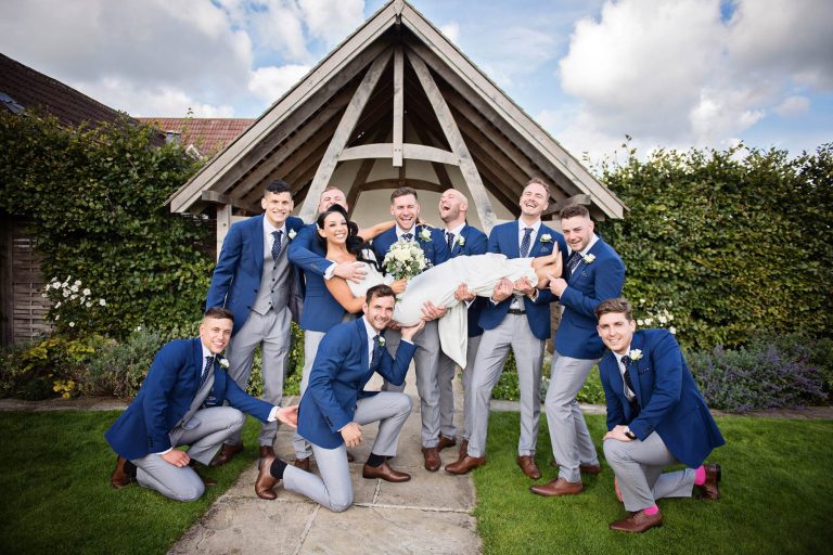 Fun formal photographs of groomsmen and bride at Kingscote Barn