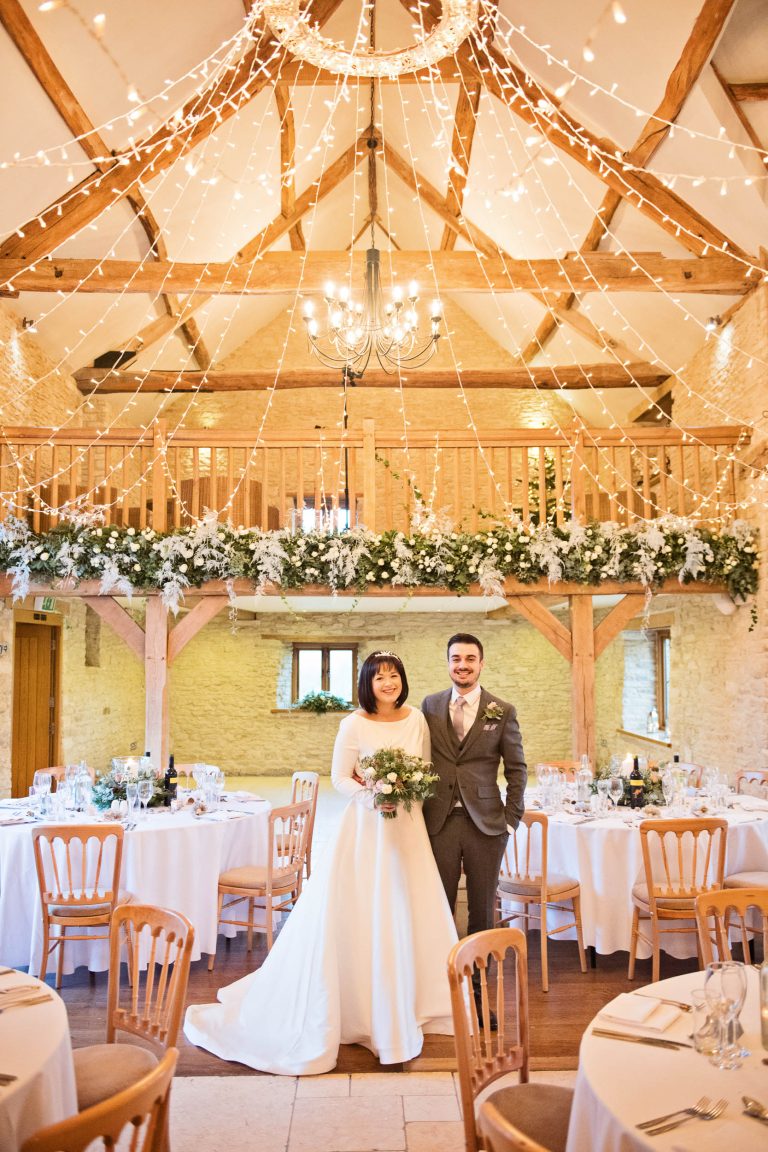 Bride and groom at Kingscote Barn wedding breakfast set up.