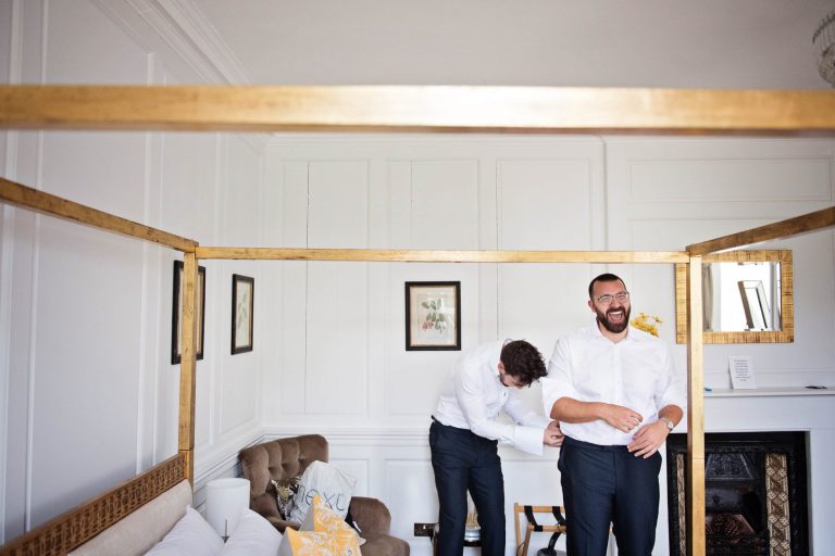 Groom laughing as he gets ready at Syrencot.