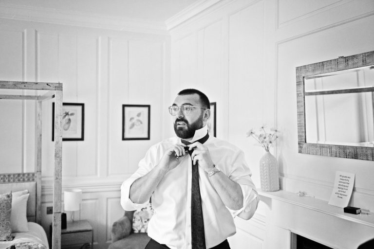 Candid photo of the groom looking nervous as he gets ready.