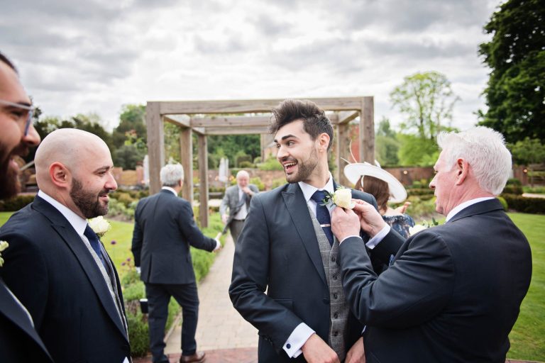 Groomsmen getting their button holes on.