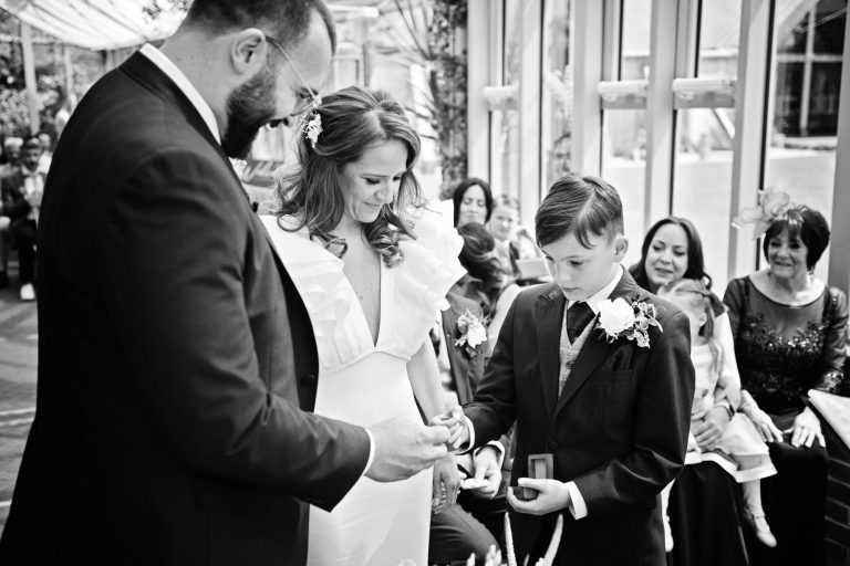 Page boy, handing the groom his brides wedding ring. B&W photo.