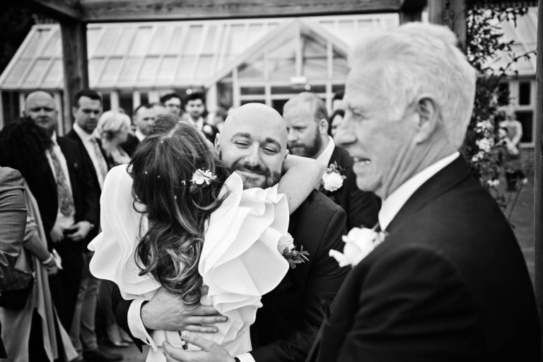 Candid photo of bride being hugged by a wedding guest at Syrencot.