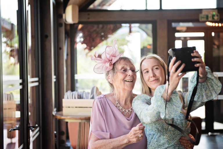 Candid photo of wedding guests doing a selfie during the wedding breakfast at Syrencot.