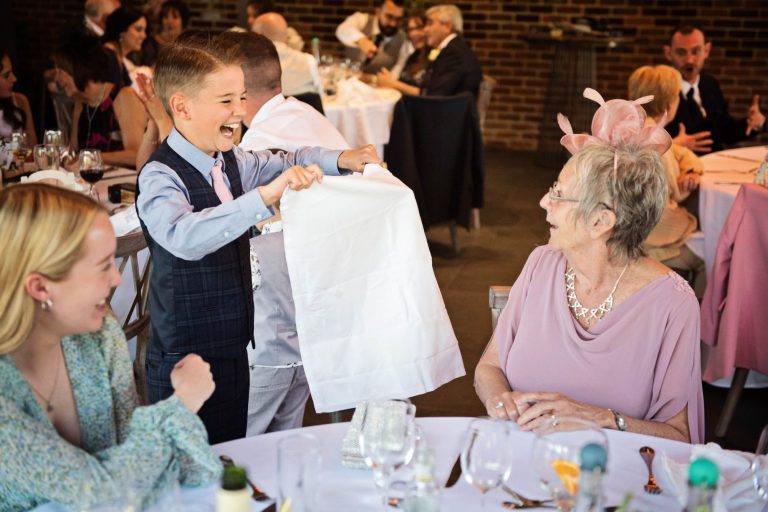 Child playing the knife, napkin game to an unsuspecting wedding guest.