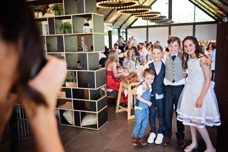 Candid photo of kids during the wedding breakfast. Posing to another camera.