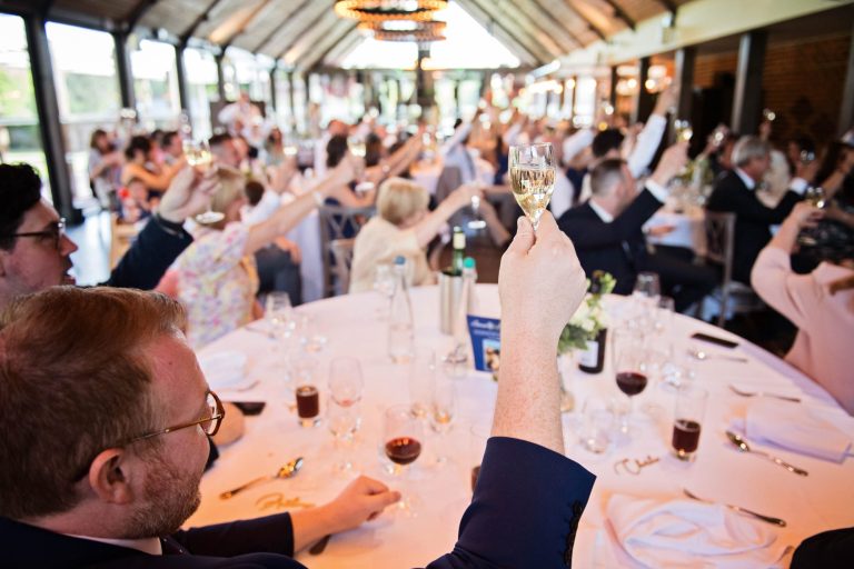 Wedding guest raising his glass during the wedding speeches.