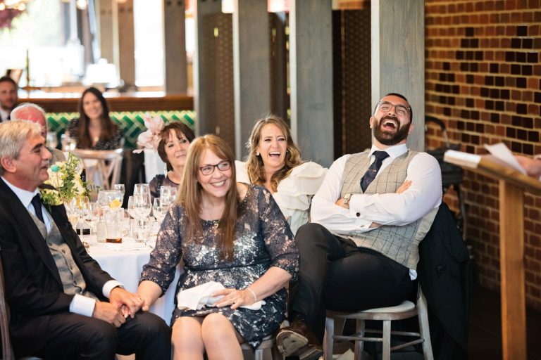 Bride and groom and close family laughing during the wedding speeches at Syrencot.