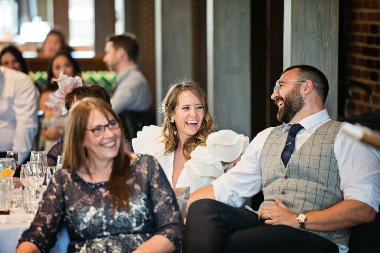 Bride and groom laughing during the wedding speeches.