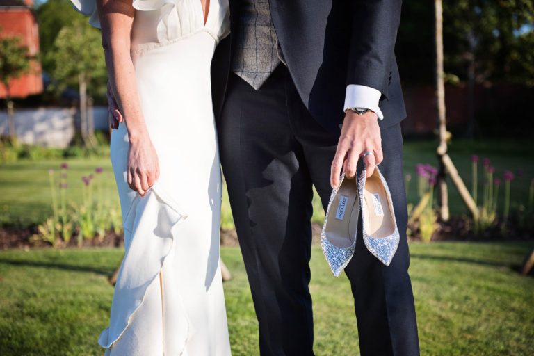 Groom carrying the brides Jimmy Choo wedding shoes.