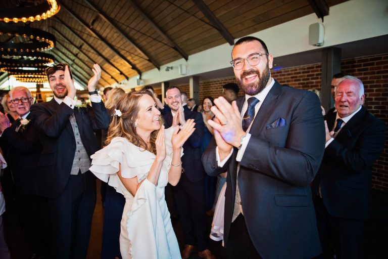 Bride and groom clapping at the end of their 1st dance.
