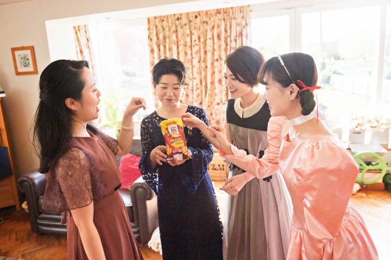 Girls eating Walkers crisps. Candid photograph by Blooming Photography.