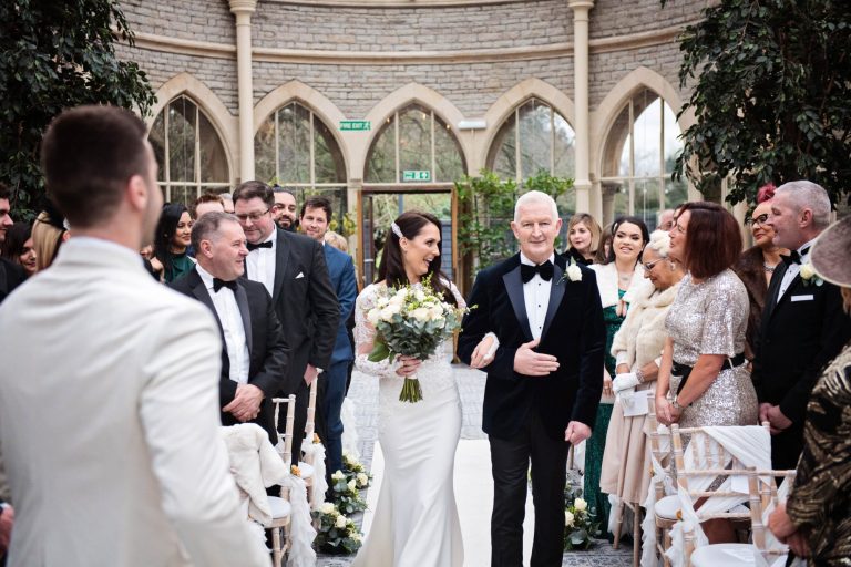 Documentary photo of bride walking down the isle at their wedding in the Orangery at Tortworth Court.