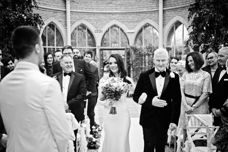 B&W documentary photo of bride and groom seeing each other for the first time at their wedding in the Orangery at Tortworth Court.