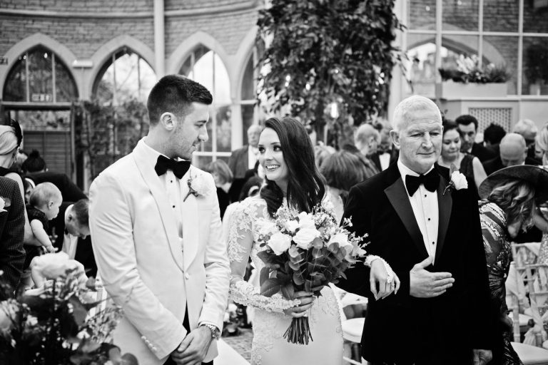 B&W documentary photo of bride and groom seeing each other for the first time at their wedding in the Orangery at Tortworth Court.