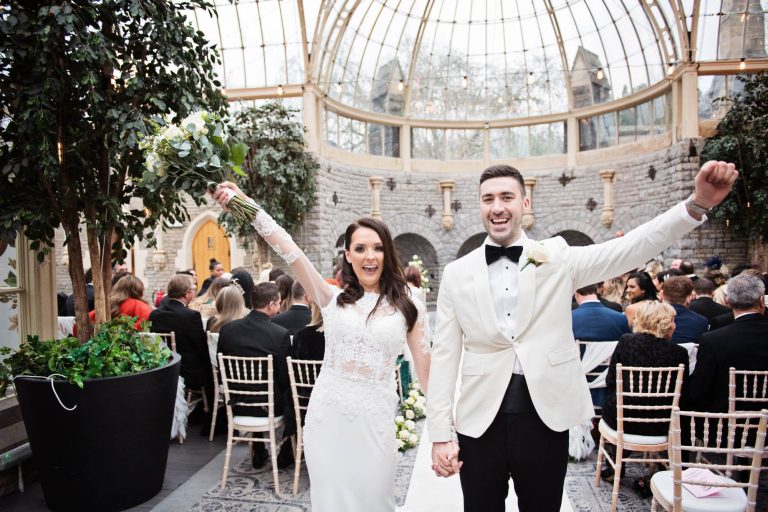 Bride and groom raise their arms up in the air after their wedding ceremony at Tortworth Court.