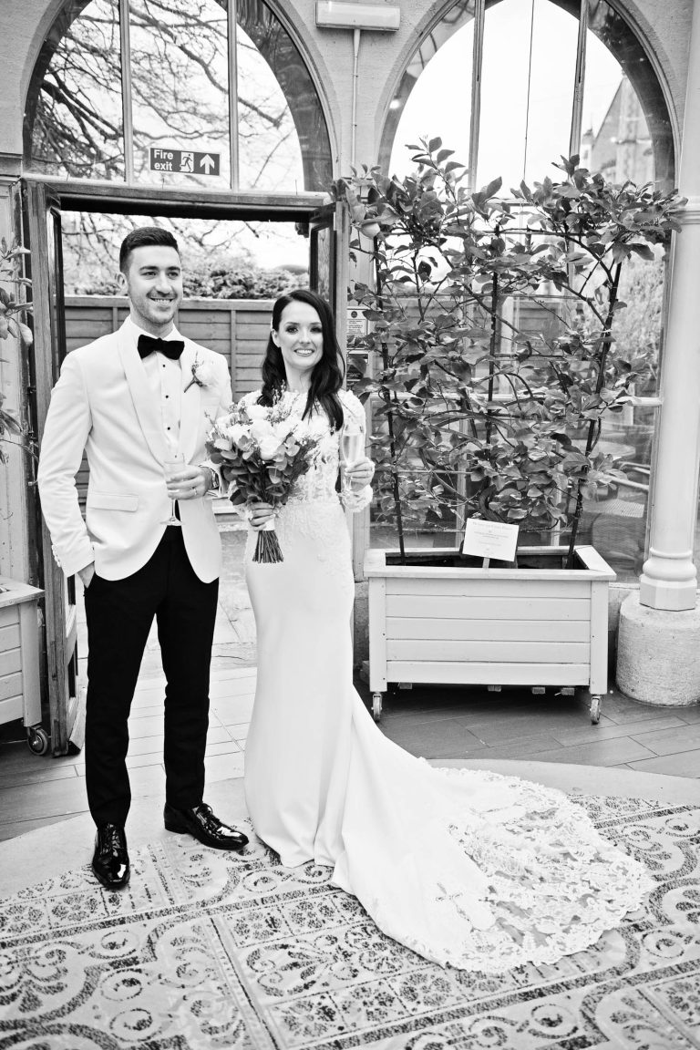 Portrait b&w photo of bride and groom in the Orangery at Tortworth Court.