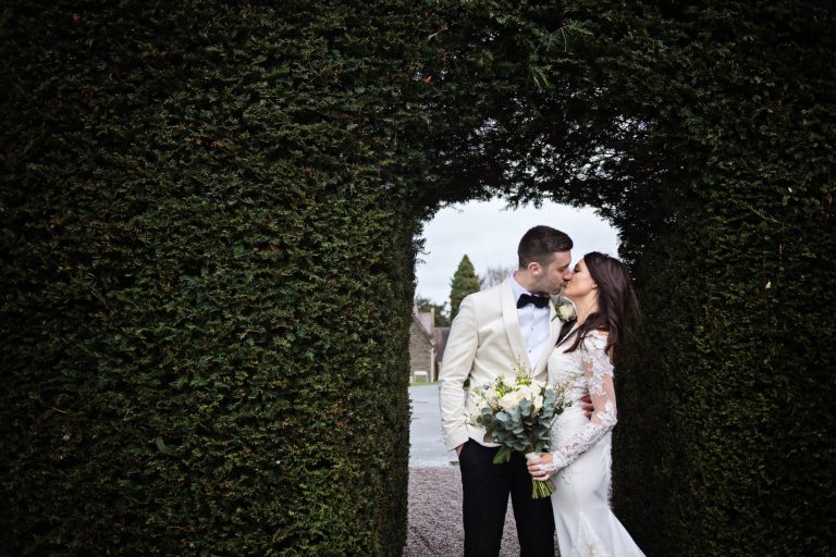 Bride and groom kiss in the grounds and gardens of Tortworth Court.