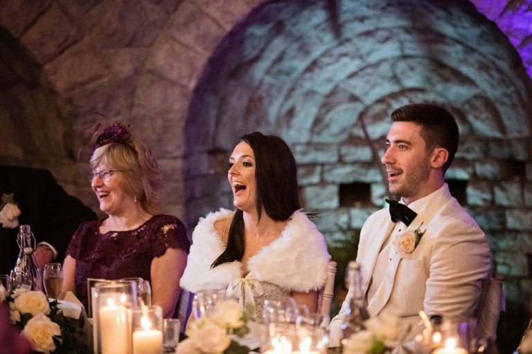 Candid photo of bride laughing during speeches.
