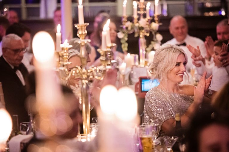 Candles and wedding guests clapping during wedding speech at Tortworth Court.