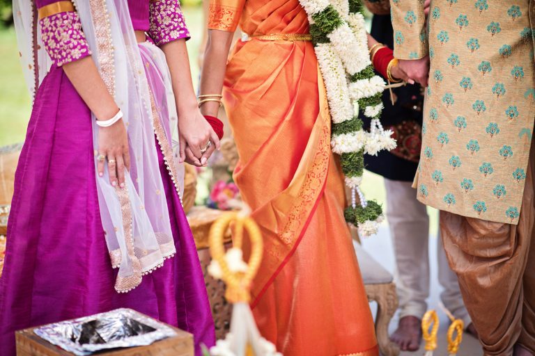 Holding hands during Hindu ceremony at North Mymms Park, candidly photographed by Blooming Photography.