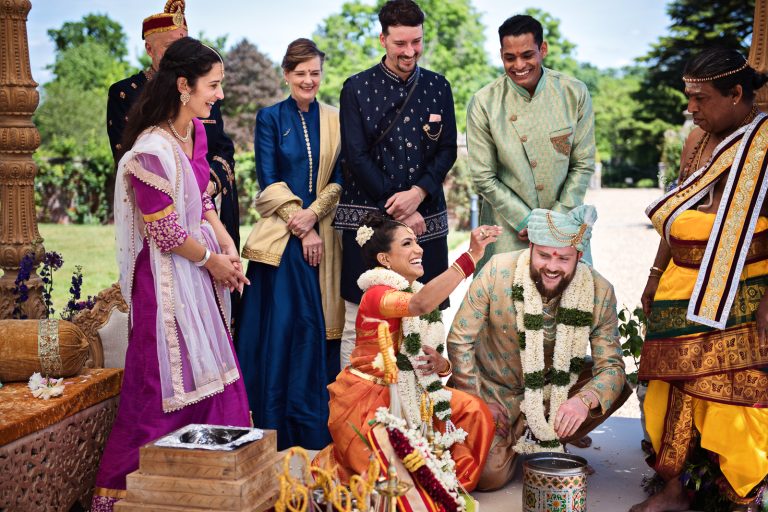 Finding the ring during Hindu ceremony at North Mymms Park, candidly photographed by Blooming Photography.