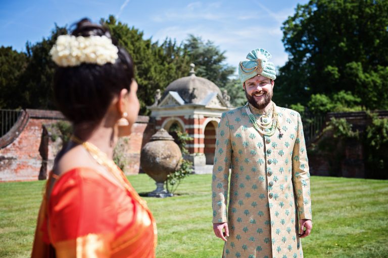 Bride looking at groom after Hindu ceremony at North Mymms Park, candidly photographed by Blooming Photography.