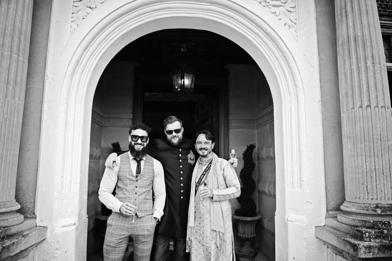 Guest smile under arch at North Mymms Park, black & white photo candidly photographed by Blooming Photography.