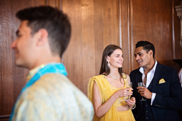 Guests chat together at North Mymms Park, candidly photographed by Blooming Photography.
