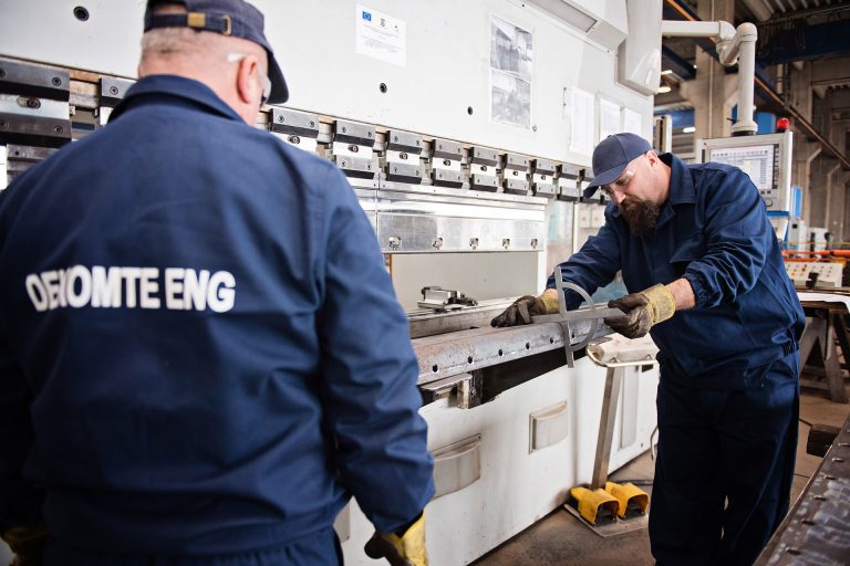 Two workers measuring an expansion joint in a manufacturing factory in Romania.