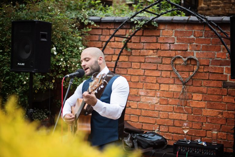 Musician playing his guitar at a wedding.