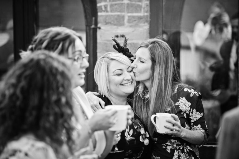 B&W candid photo of wedding guests enjoying themselves