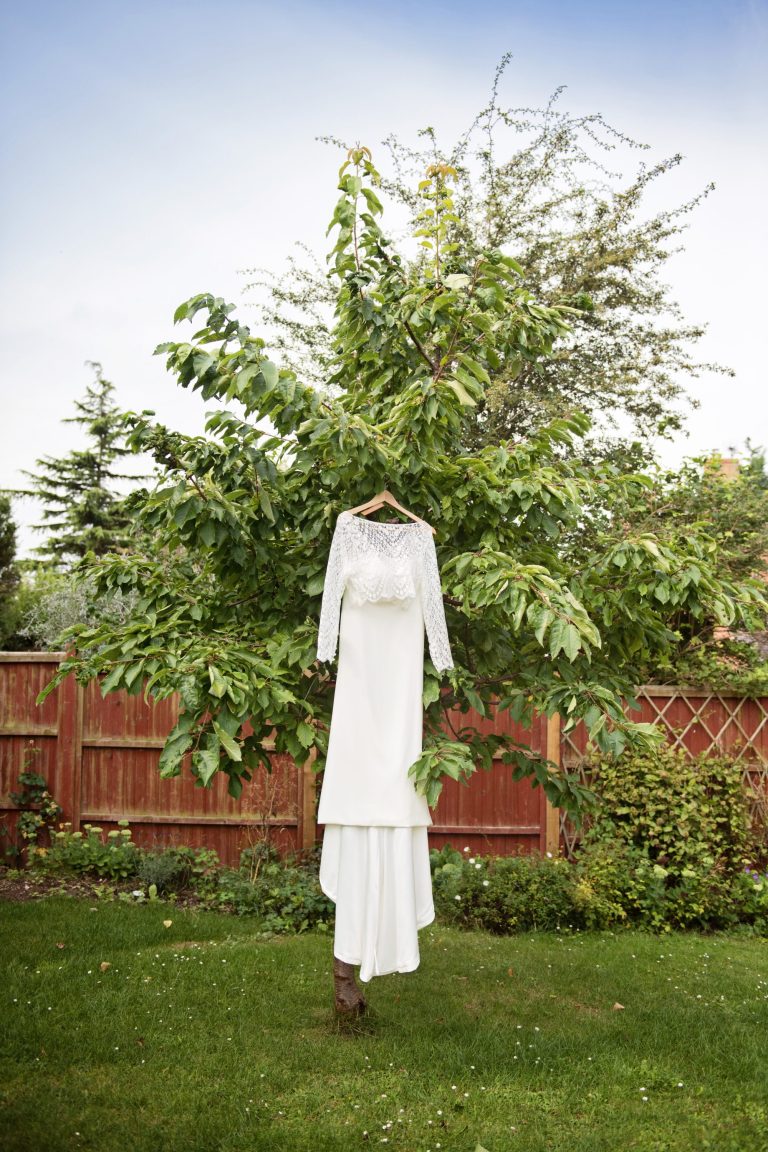 Brides wedding dress hung up in a cherry tree.