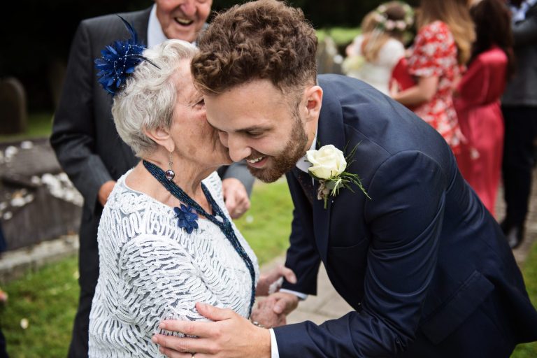 Candid image of groom having a hug and kiss off his grandma