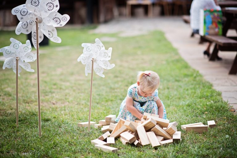 Candid wedding photo of a child playing with Jenga bricks at Gloucestershire wedding venue Over Barn, Gloucester.