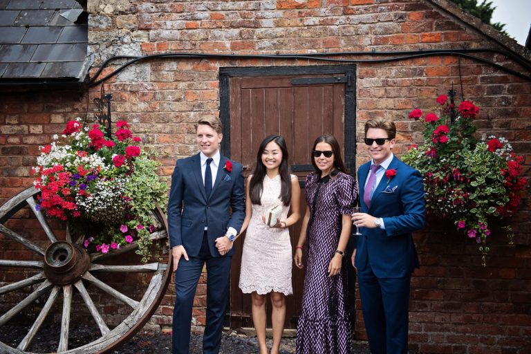 Candid wedding photo of guests posing for another camera at Overbarn, Gloucester