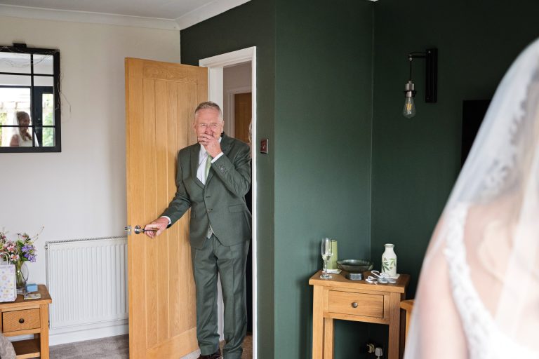 father of the bride in shock as he is seeing his daughter in her wedding dress for the first time