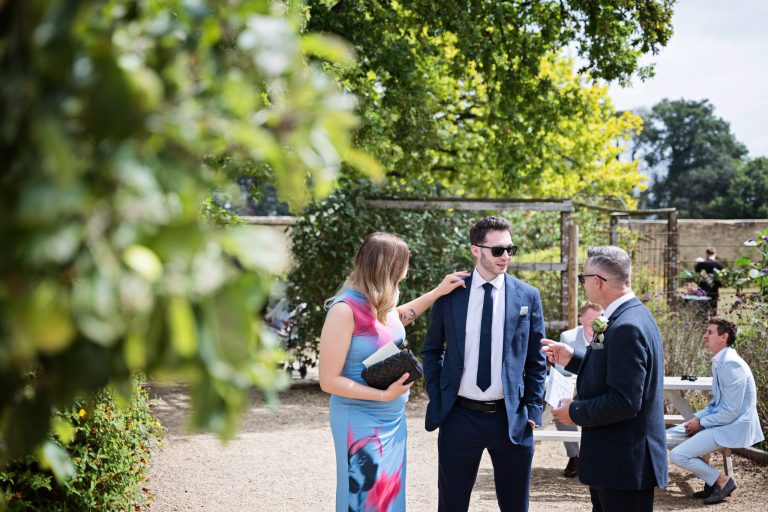 people chatting pre wedding in a garden on a sunny summers day