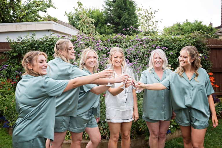 team bride celebrate in the garden with a glass of fizz