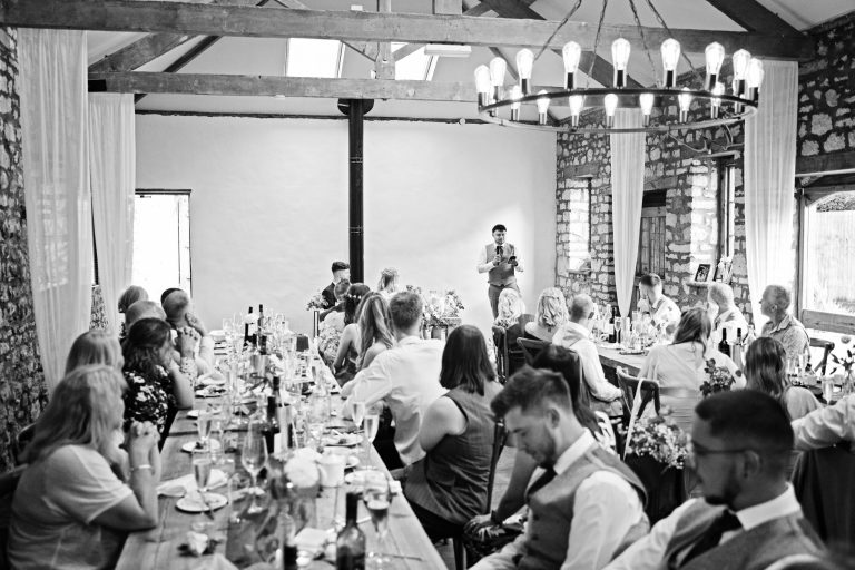 B&w image of guests listening to a best mans speech