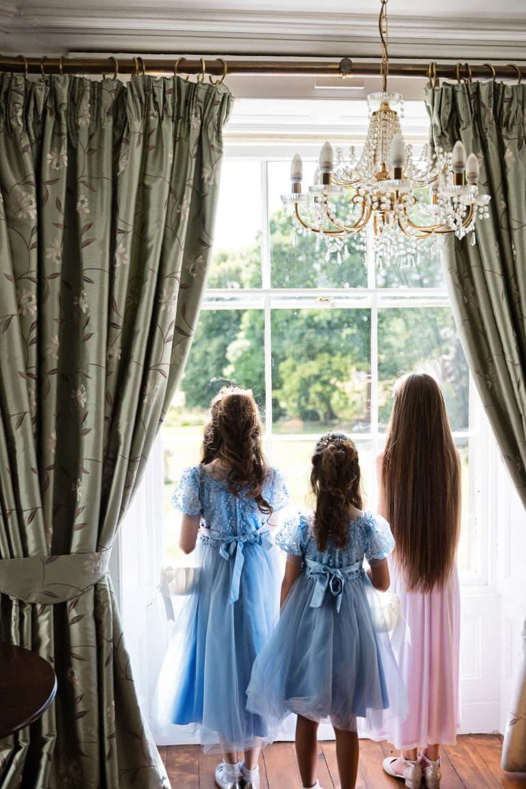 three flower girls look out of a Georgian Bay window.