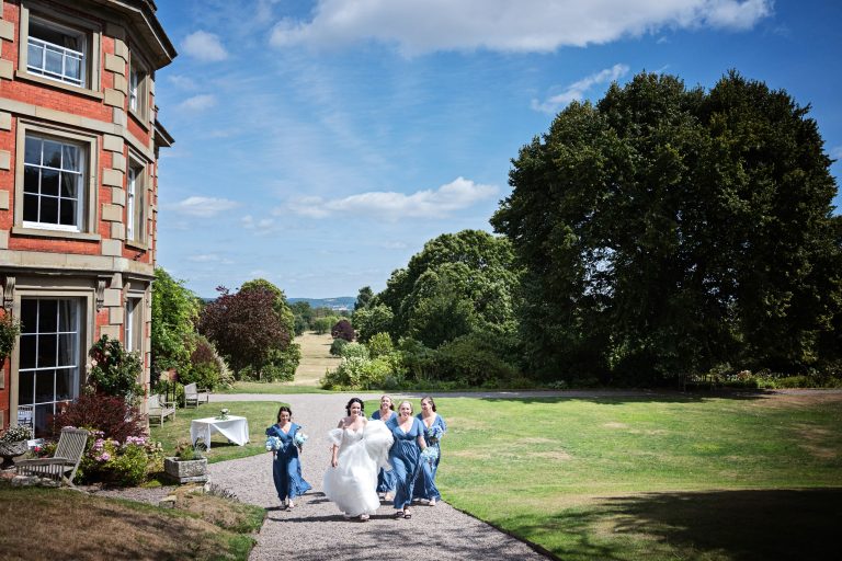 Bride and bridesmaids walk past a Georgian House on their way to the wedding