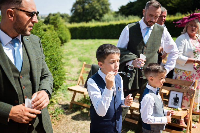 a boy at a wedding blows bubbles