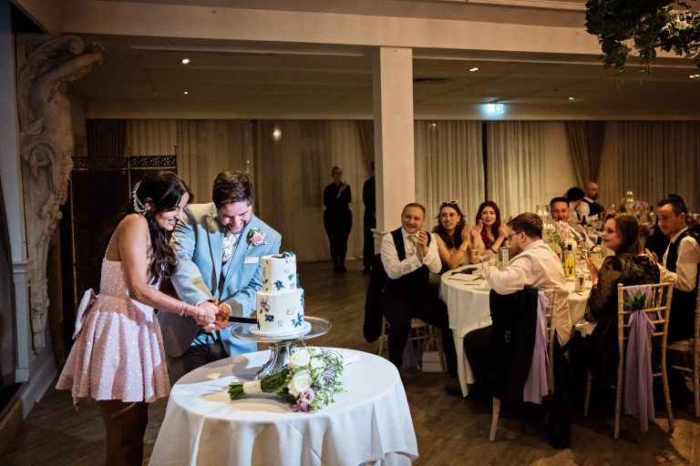 Candid cutting of the cake at Manor By The Lake by Blooming Photography