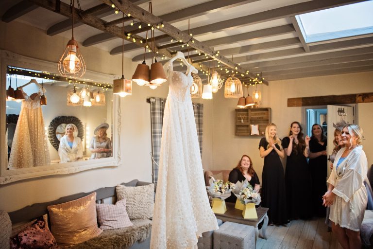 Team bride look at the wedding dress that is being hung up in the bridal suite at Blackwell Grange.