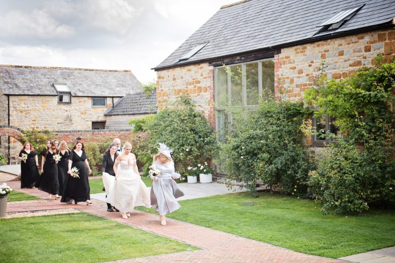 A bride walks with her bridal party on the way to get married.