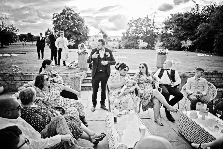 B&W image of wedding guests chatting candidly