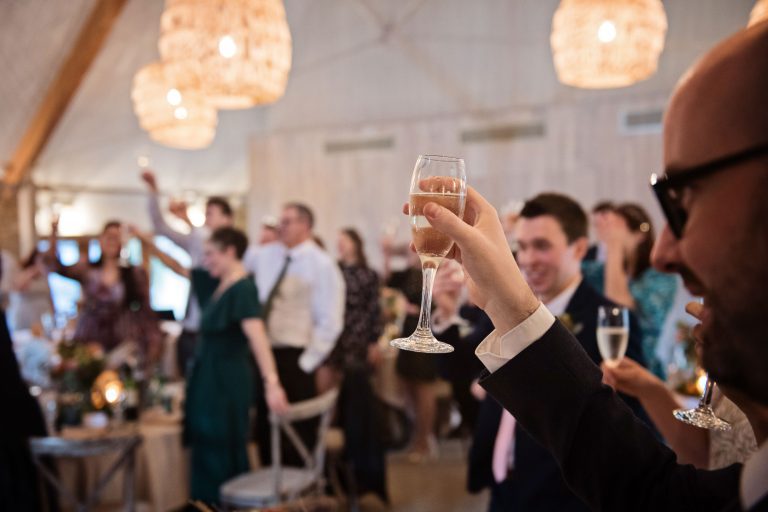 Guest raises their glass at the end of the speech at a wedding at Calcot Manor.