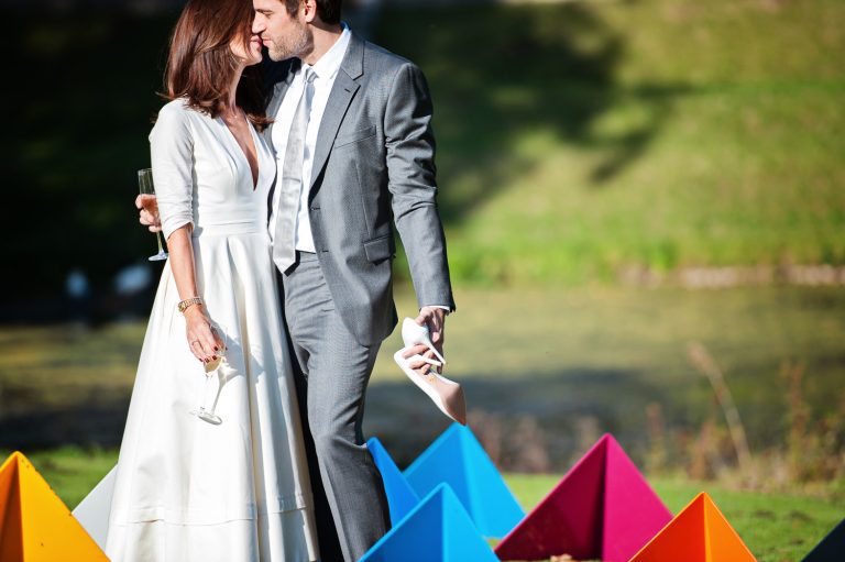 Cool image of bride and groom kissing in the grounds of Cowley Manor.