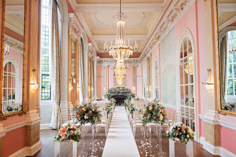 Interior photograph of a luxurious wedding ceremony room at Danesfield House. Chandelier's and ornate fixings and large mirrors make this truly special.